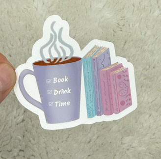 A sticker featuring a coffee mug with steam and three colorful books beside it, labeled 'Book', 'Drink', and 'Time'.