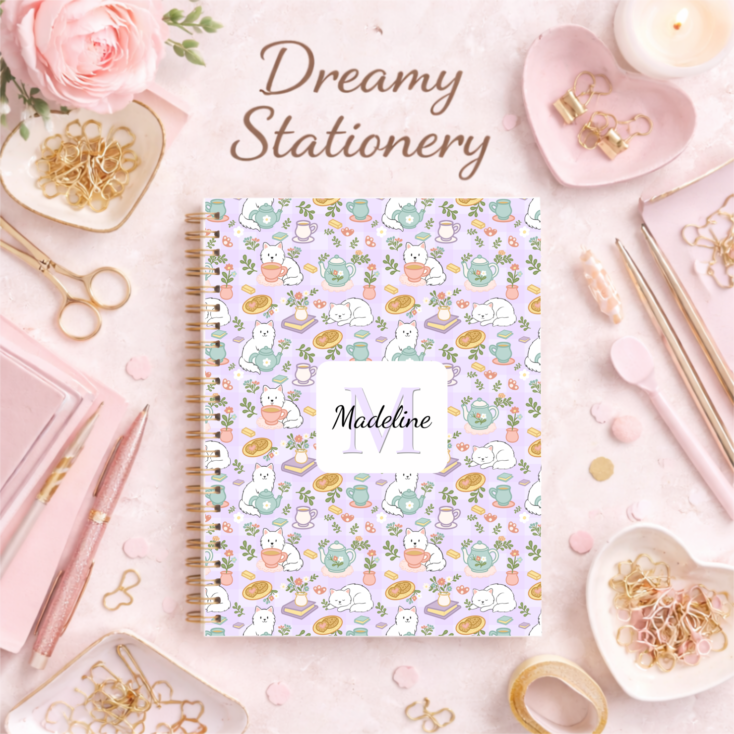 A beautifully designed notebook with a pastel purple cover featuring whimsical illustrations of cats, teacups, and flowers. The title 'Dreamy Stationery' is written above the notebook, and the name 'Madeline' is prominently displayed on the cover.